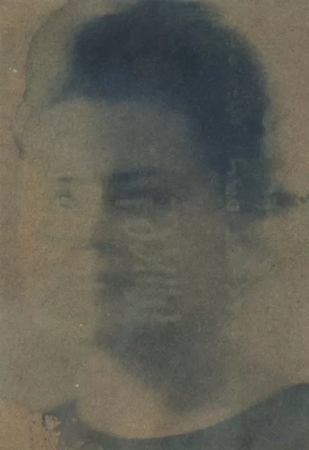 A Cyanotype of a blurred woman's face on brown paper faint writing